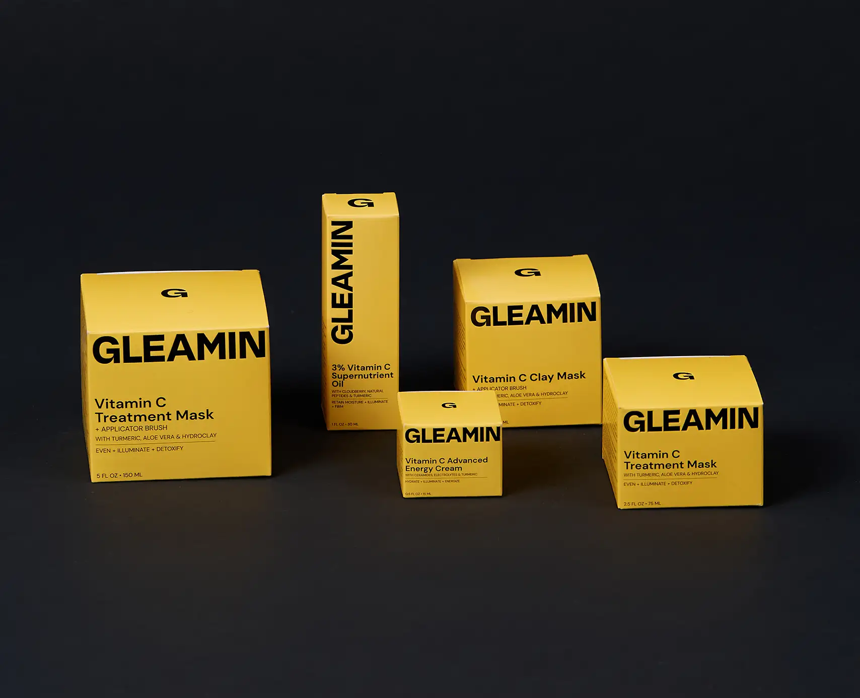 Close-up of a yellow product packaging box with a metallic letter ‘G’ on top and the word ‘GLEAMIN’ printed vertically on the side.