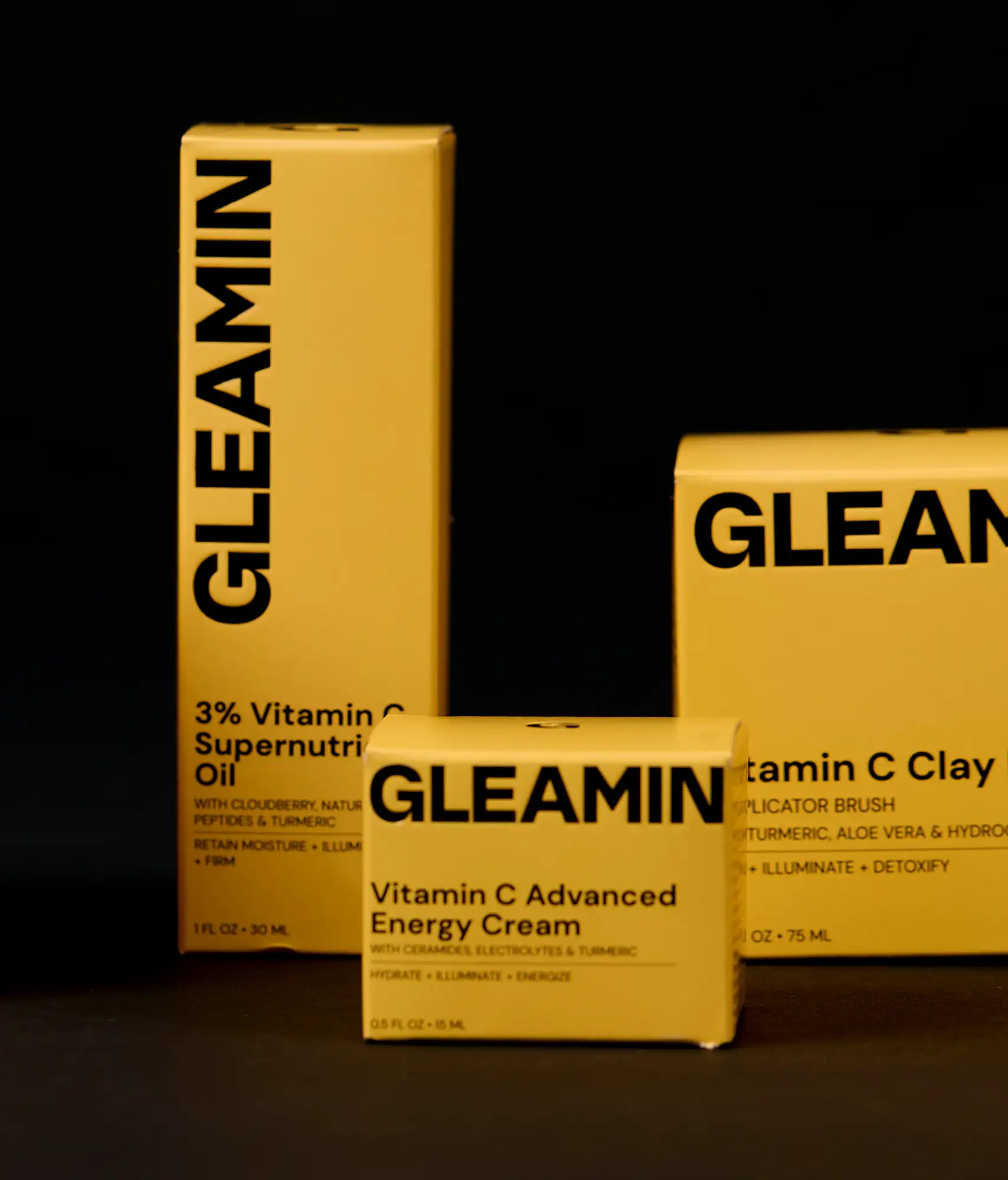 Close-up of a yellow product packaging box with a metallic letter ‘G’ on top and the word ‘GLEAMIN’ printed vertically on the side.